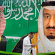 People walk past a banner showing Saudi King Salman, right, and his Crown Prince Mohammed bin Salman, outside a mall in Jiddah, Saudi Arabia.